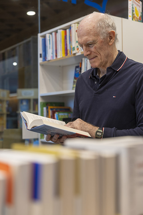 El sociólogo Álex Navas junto a una estantería de libros